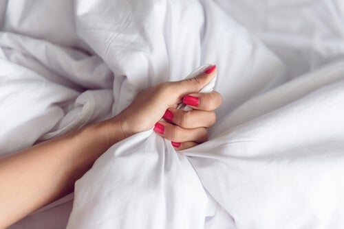 Mano de una mujer cogiendo la sábana