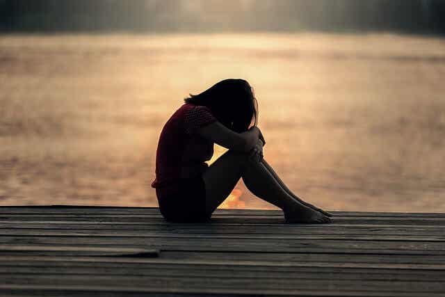 Chica adolescente llorando en el puerto por la violencia en las parejas de adolescentes como la suya