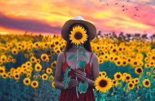 chica con girasol feliz por aplicar las teorías de Martin Seligman