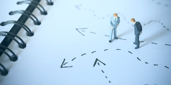 Figuras de hombres mirando las flechas del suelo