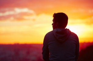 Hombre de espaldas viendo el atardecer