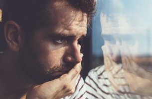 Hombre triste ante un cristal
