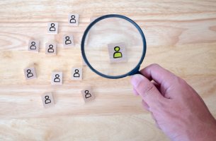 Lupa enfocando a un monigote para representar el estudio de la personalidad
