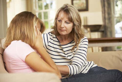 Madre consolando a su hija adolescente y preguntándose cómo ayudar a un adolescente