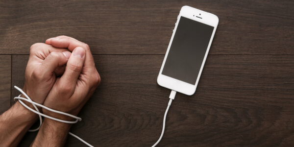 Manos encadenadas a un móvil