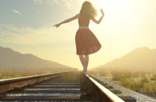 Mujer caminando por la vía del tren