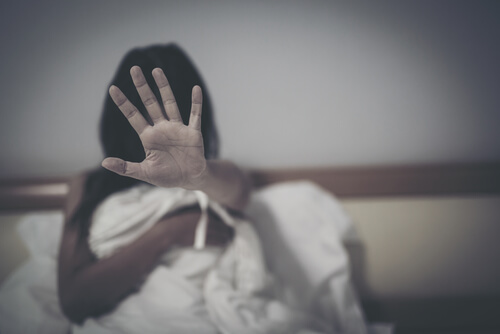 Mujer con miedo en la cama