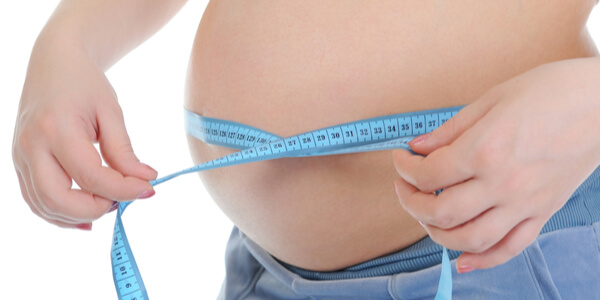 Mujer con pregorexia midiéndose la barriga