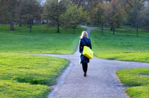Mujer en mitad de cuatro caminos para representar la decisión a través de sesgos cognitivos