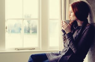 mujer frente a ventana que disfruta de sus pausas