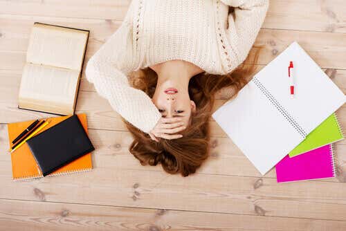 Mujer perfeccionista estresada tumbada en el suelo para representar los tipos de procrastinación