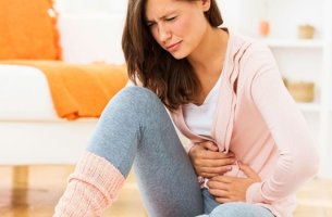 Mujer que se coge el estómago por estrés y gastritis