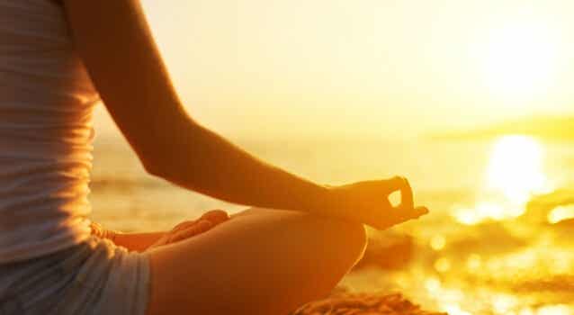 mujer ante el amanecer practicando mantras para meditar