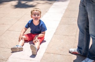 Niño con trastorno de desregulación disruptiva del estado de ánimo en el suelo llorando