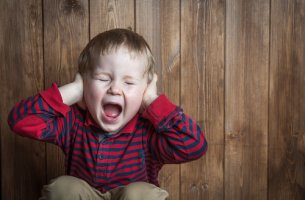 Niño tapándose los oídos por una rabieta