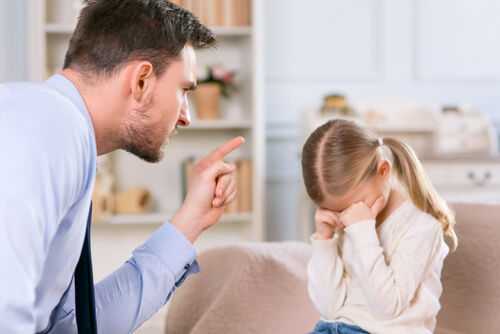 Padre castigando a su hijo mientras llora