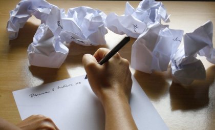 Personne écrivant sur un morceau de papier appliquant la technique de résolution de problèmes