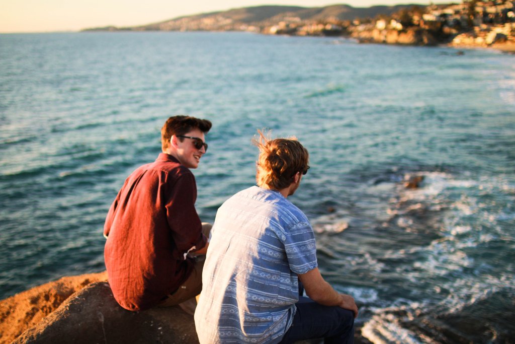 chicos hablando en la playa representando la amistad a "primera vista"