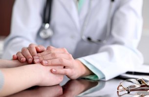 doctora cogiendo las manos del paciente trabajando la comunicación oncológica
