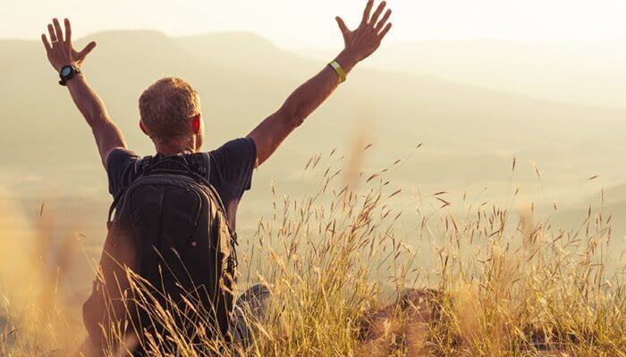hombre con los brazos extendidos disfrutando de viajar solo