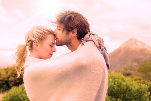 Man kissing his girlfriend's forehead