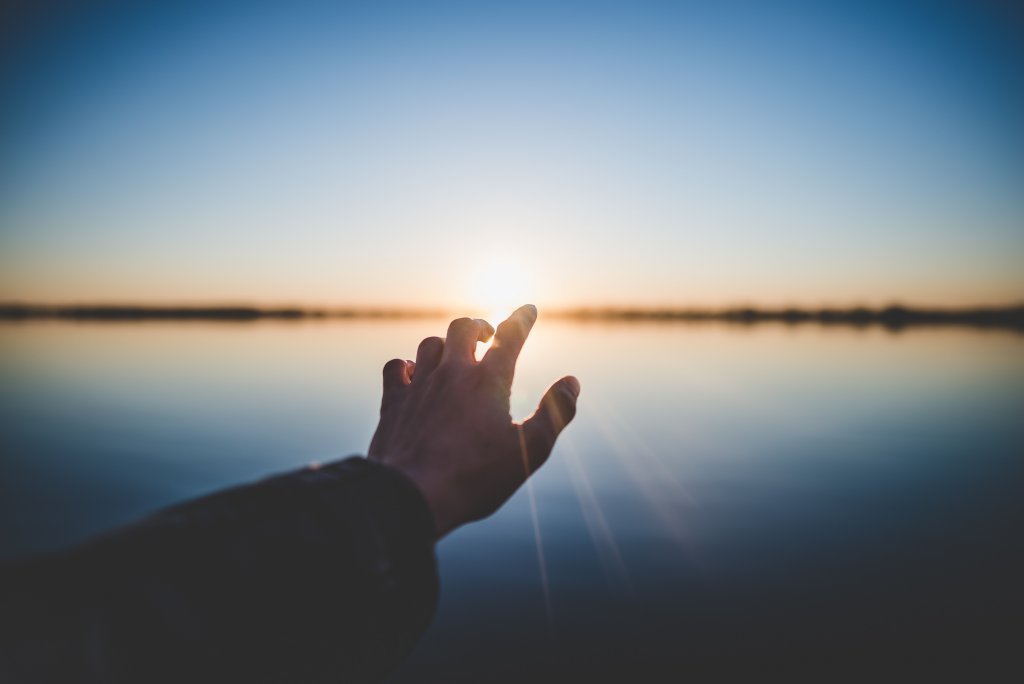 Mano con luz representando las frases para recuperar la energía positiva