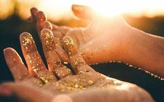 manos con polvo dorado representando el El sentido de la vida según Viktor Frankl