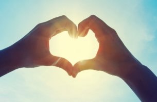 Manos haciendo una forma de corazón para simbolizar el amor platónico