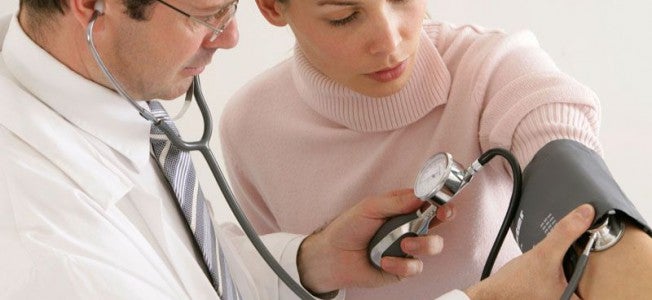 Médico midiendo la presión arterial a su paciente