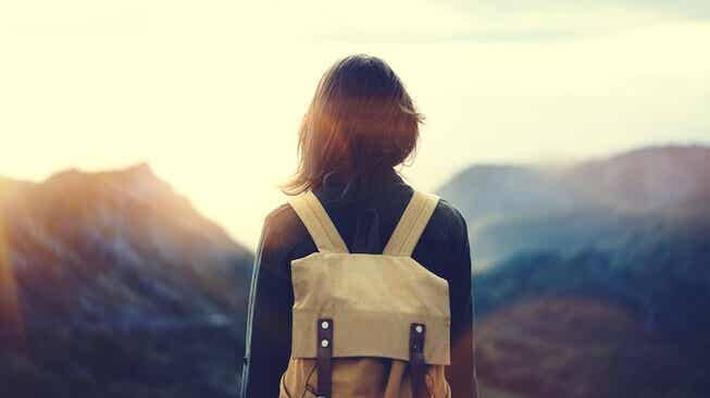 Mujer con mochila ante una montaña