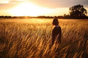 Mujer en campo de trigo pensando en el sentido de la vida según Viktor Frankl