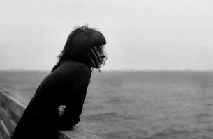 Mujer mirando al mar pensando en decir adiós