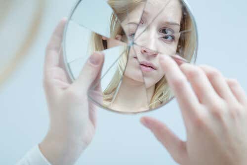 Chica adolescente mirándose al espejo intentando recuperarse de un abuso emocional