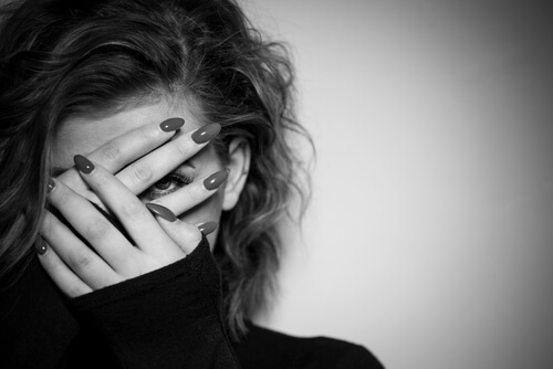 Mujer tapándose la cara por miedo