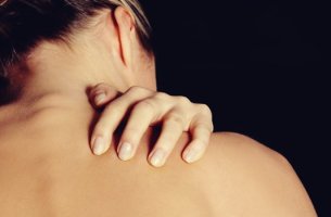 Mujer tocándose la espalda debido a el trastorno por excoriación
