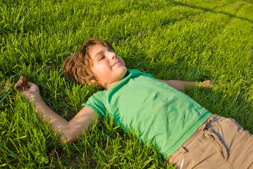 chico tumbado en el césped representando cómo criar niños independientes