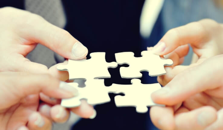 Personas uniendo las piezas de un puzzle