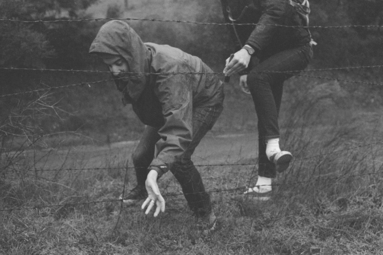 friends playing near barbed wire fence showing resilience