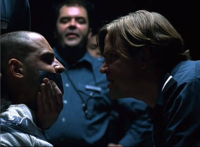 Carcelero tapando la boca a un preso en el experimento