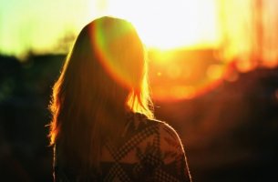 Chica de espaldas viendo el atardecer
