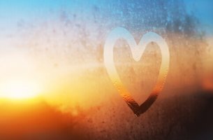 Corazón dibujado en el cristal de una ventana para representar el amor platónico