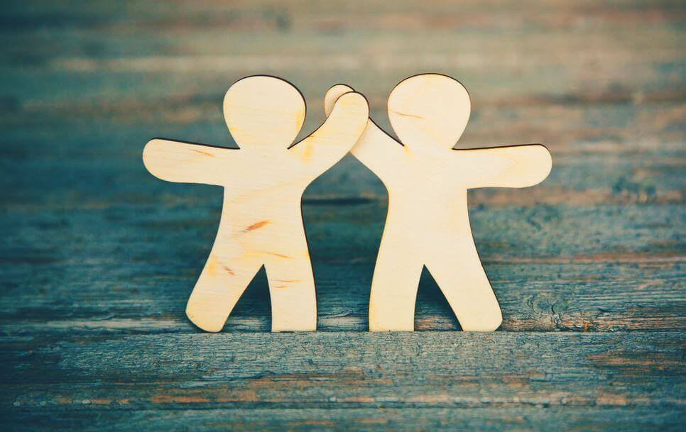 Dos figuras dándose la mano