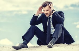 hombre con traje sentado que necesita un botiquín psicológico en la empresa