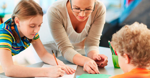 maestra con alumnos representando las frases de María Montessori