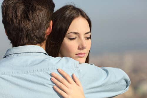 Kvinna kramar sin partner och tänker på en annan man