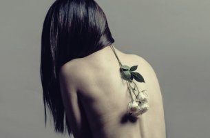 mujer con flor en la espalda que sufre trastornos psicosomáticos
