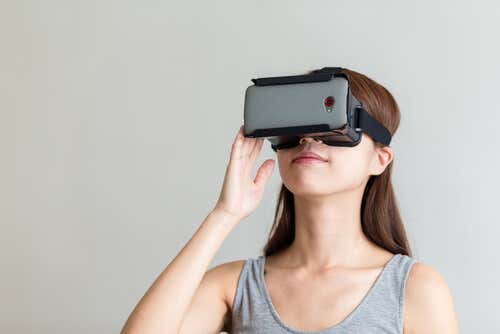 Donna che usa occhiali per realtà virtuale e cellulare per curare la paure delle altezze.
