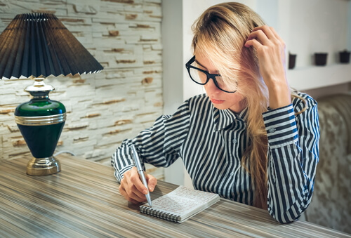 Mujer escribiendo en su bloc