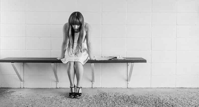 Mujer con depresión psicótica sentada en un banco