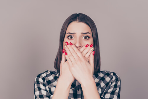 Mujer tapándose la boca mientras piensa en cómo se ve el sexo en la sociedad